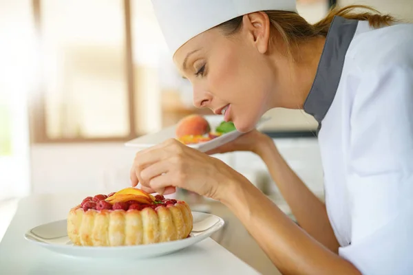 De chef van het gebakje frambozen taart versieren — Stockfoto