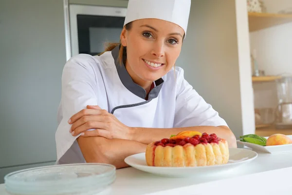 Chef standing by raspberry cake — Stock Photo, Image