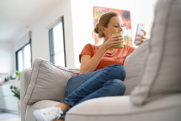 Vrouw verbonden met smartphone — Stockfoto