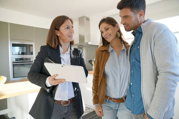 Echtpaar met agent een bezoek aan huis — Stockfoto