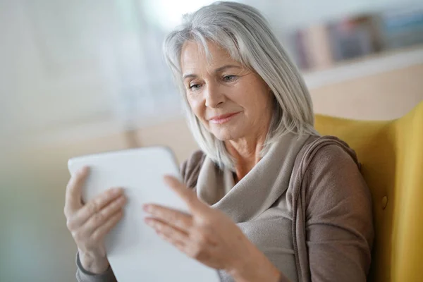 Äldre kvinna ansluten på digitala tablett — Stockfoto