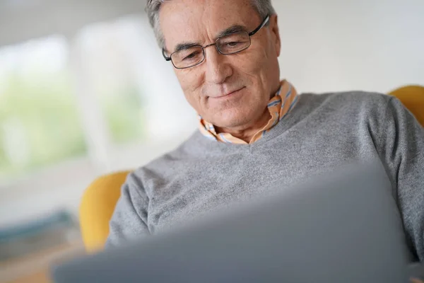 Uomo con occhiali collegati su laptop — Foto Stock