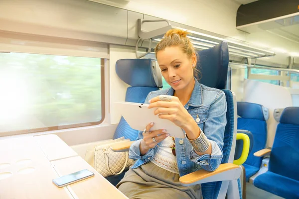 Vrouw in de trein aangesloten op Tablet PC — Stockfoto