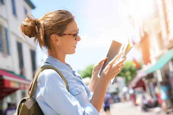 Girl reading map and using tablet — Stock Photo, Image