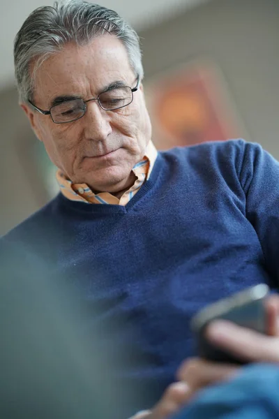Старший чоловік використовує смартфон — стокове фото