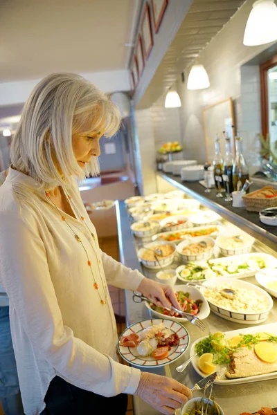 Woman in restaurant helping hersel — Stock Photo, Image