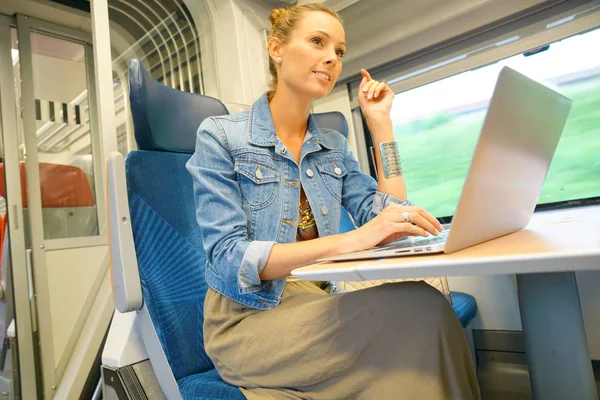 Frau im Zug mit Laptop verbunden — Stockfoto