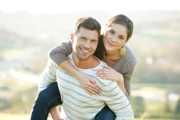 Man giving piggyback ride to girlfriend