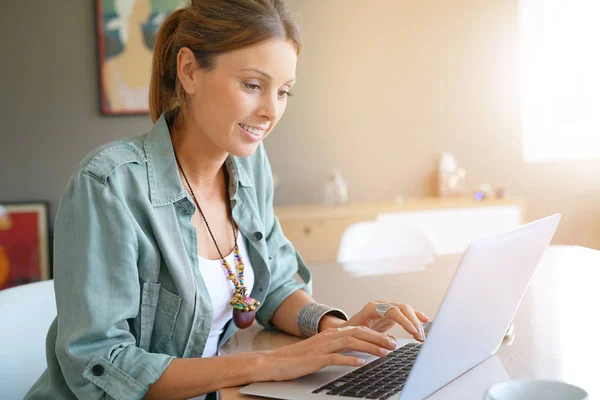 Mulher em casa trabalhando no laptop — Fotografia de Stock