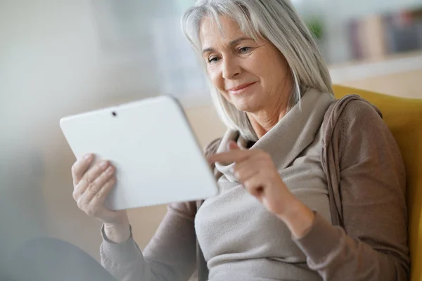 Mujer mayor conectada en tableta digital — Foto de Stock