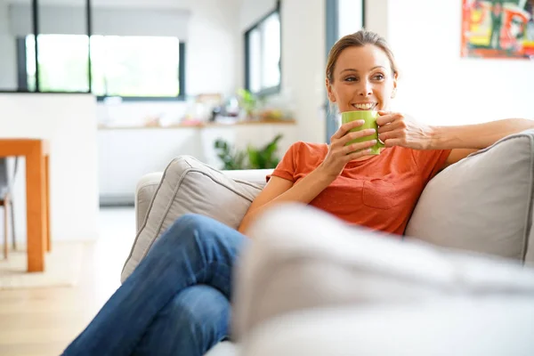 Kobieta w sofę i picie herbaty — Zdjęcie stockowe