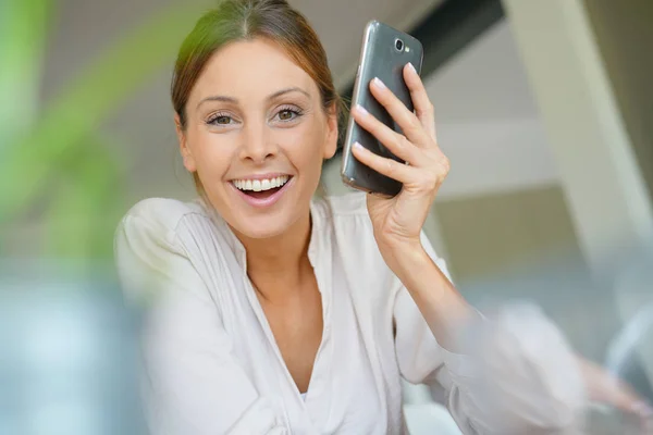 Frau zu Hause mit Smartphone — Stockfoto