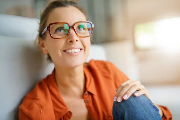 Mädchen mit trendiger Brille sitzt Stockfoto