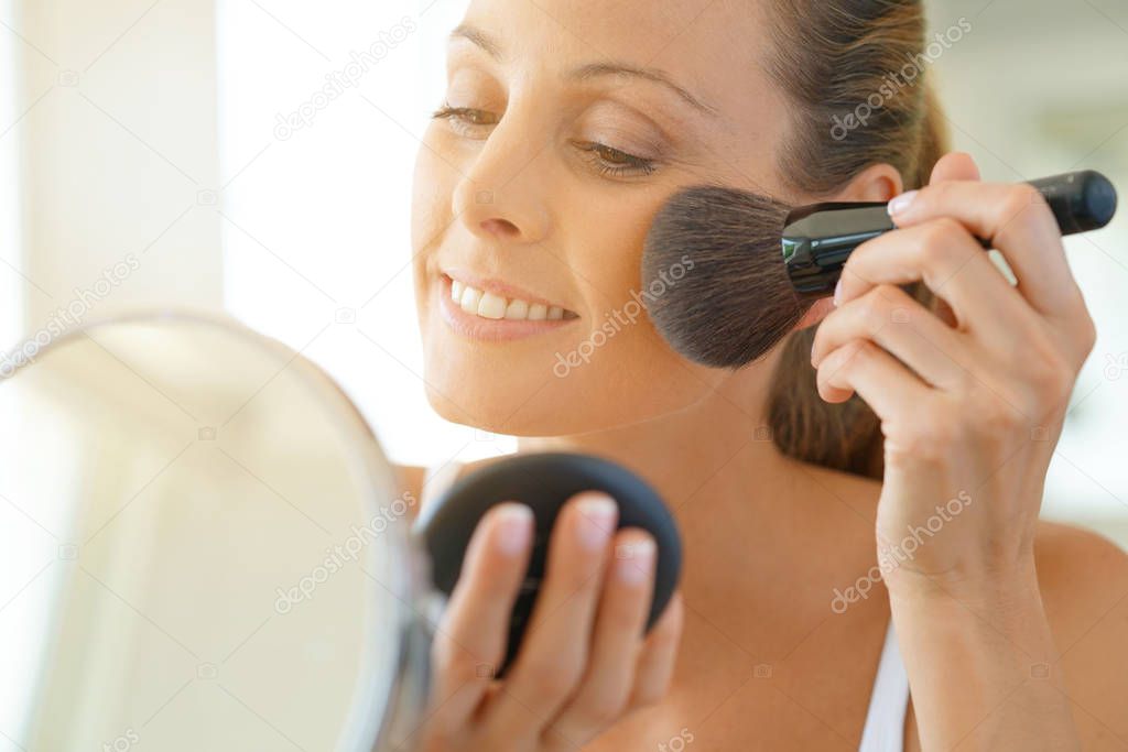 woman putting makeup on
