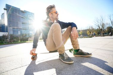 kaykay parkı üzerinde oturan adam                  