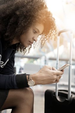 Akıllı telefon kullanan genç bir kadın.