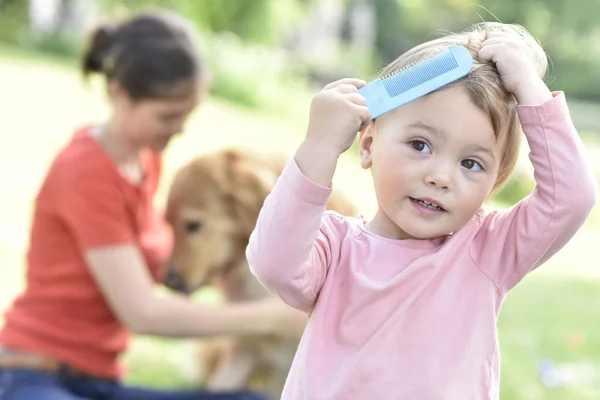 Girl trying to comb her hair — Stock Photo, Image