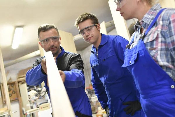 Carpenter with apprentices  in workshop — Stock Photo, Image