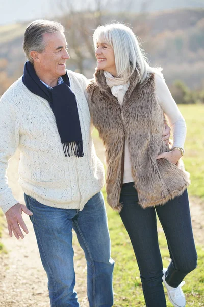 Pareja mayor caminando en el campo — Foto de Stock