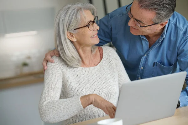 Casal em casa usando computador portátil — Fotografia de Stock