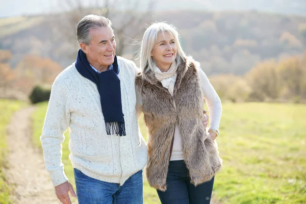 Pareja mayor caminando en el campo — Foto de Stock