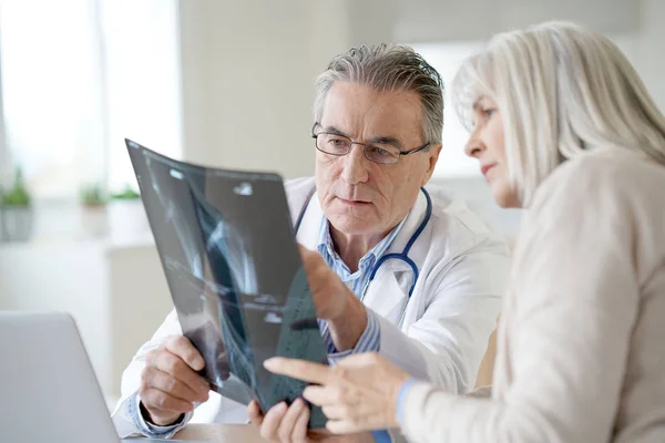 Läkare med patienten tittar på röntgen — Stockfoto