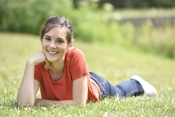 Jonge vrouw in gras te leggen — Stockfoto