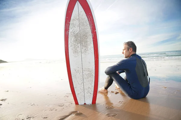 Surfare som sitter på sandstranden — Stockfoto