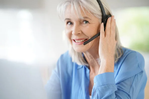 Seniorkvinne i telefonavdelingen – stockfoto