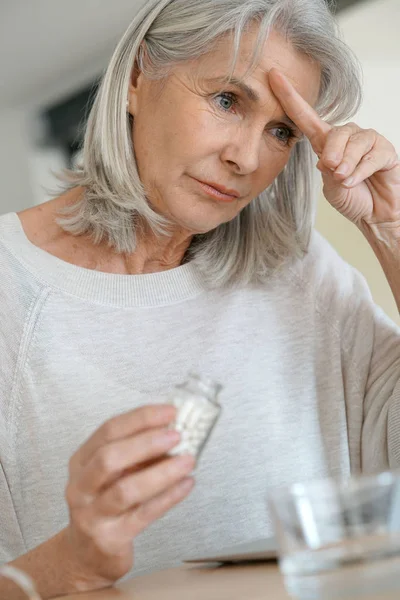 Mujer tomando píldora para aliviar la migraña — Foto de Stock