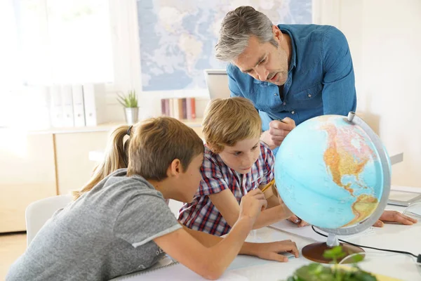 Insegnante con bambini in classe di geografia — Foto Stock