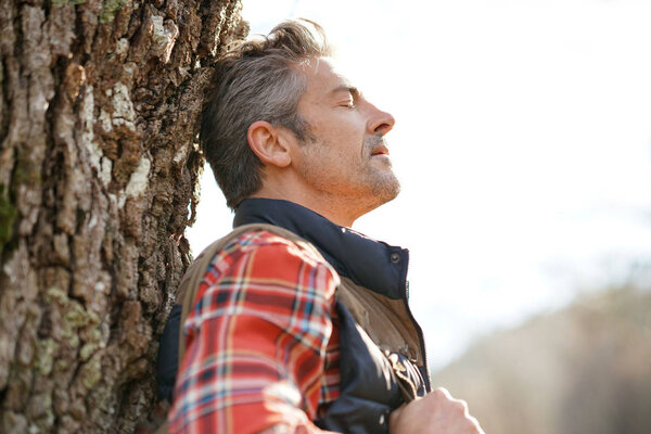 Hiker relaxing by tree 