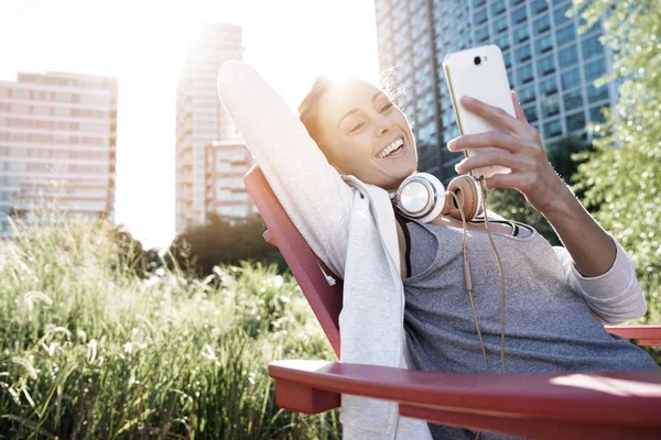 Ragazza allegra collegata su smartphone — Foto Stock