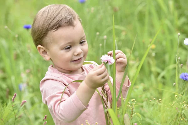 Chica jugando en salvaje flor campo — Foto de Stock