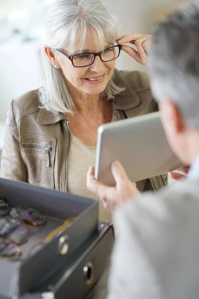 Mujer mayor probándose anteojos —  Fotos de Stock