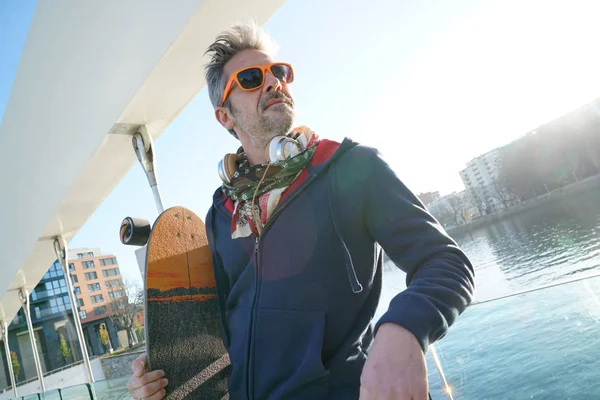 Trendy guy with skateboard — Stock Photo, Image