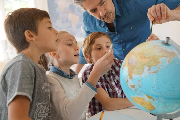 Professor com crianças na aula de geografia — Fotografia de Stock