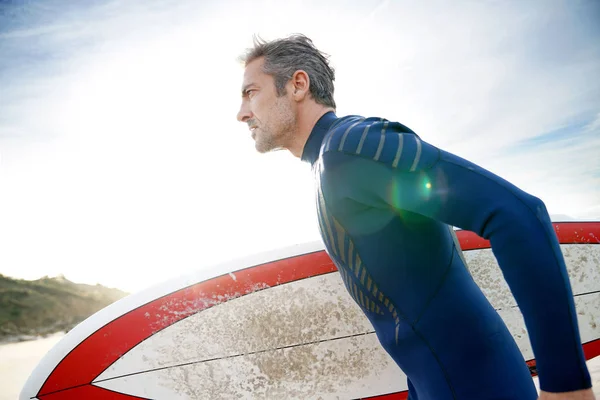 Surfer op het strand houden surfplank — Stockfoto