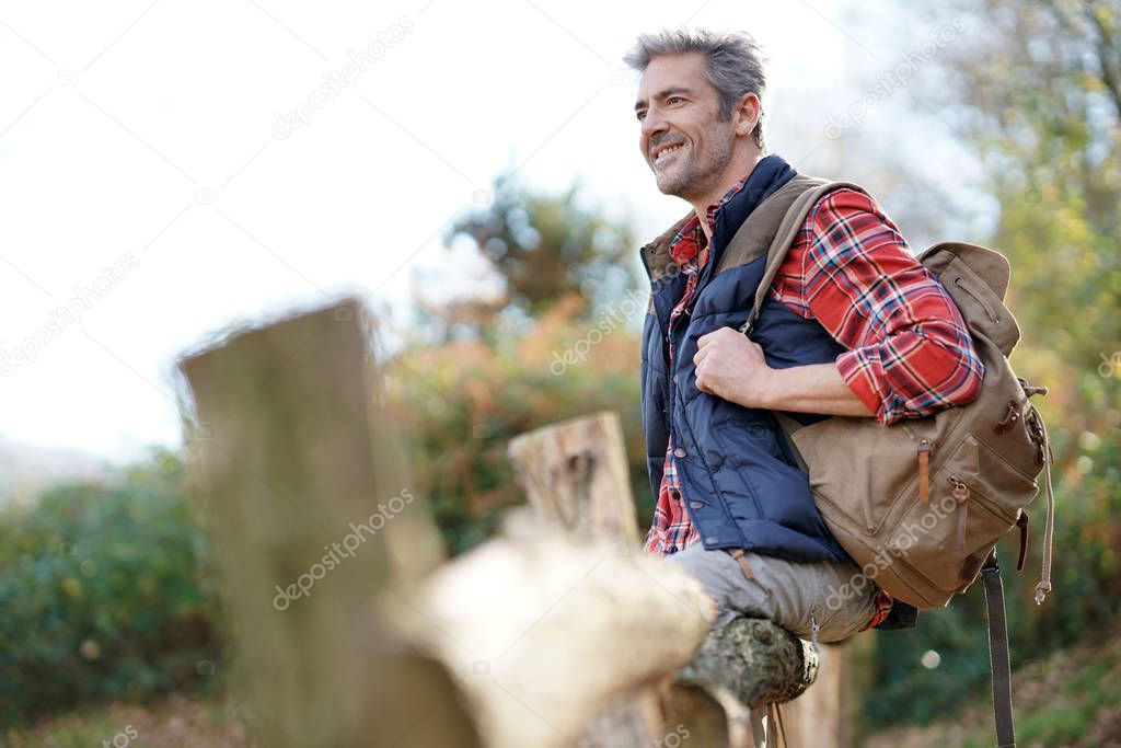 Hiker relaxing by fence