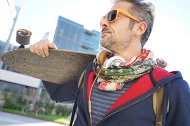 Kaykay omuz üzerinde tutarak kaykaycı