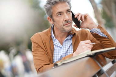 İş adamı telefonda konuşuyor.