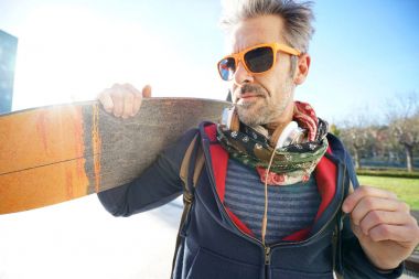 Kaykay omuz üzerinde tutarak kaykaycı