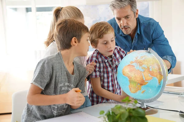 Insegnante con bambini in classe di geografia — Foto Stock