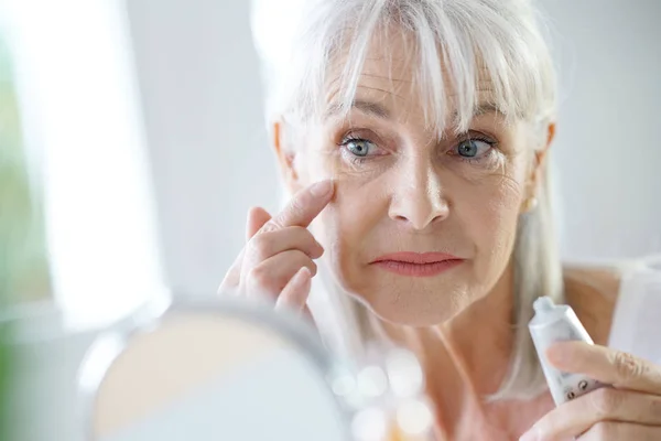 Donna che applica crema anti-invecchiamento — Foto Stock