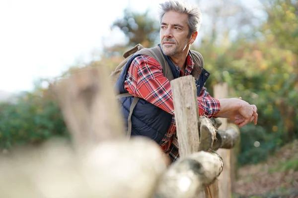 Hiker relaxing by fence — Stock Photo, Image