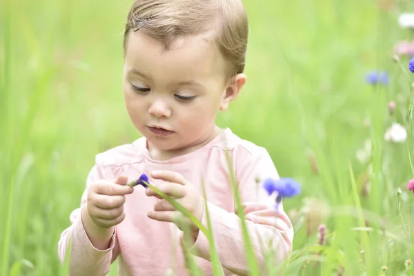 Mädchen spielt in Wildblumenfeld — Stockfoto