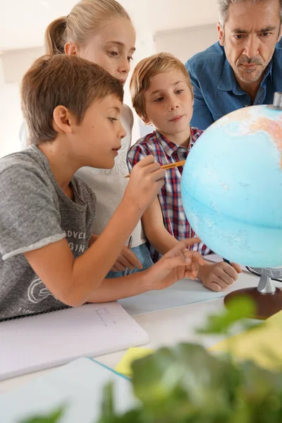 Insegnante con bambini in classe di geografia — Foto Stock