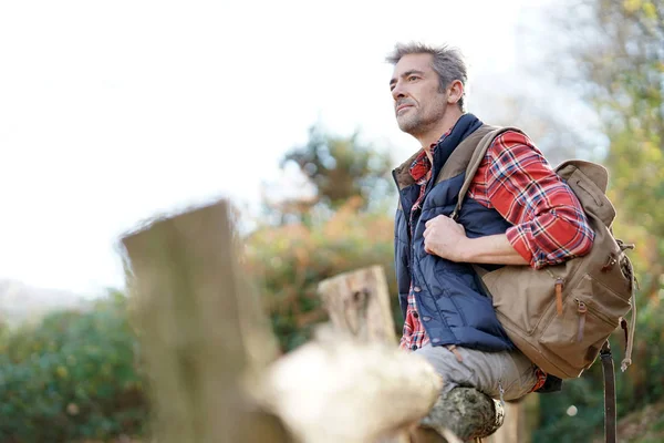 Hiker relaxing by fence — Stock Photo, Image