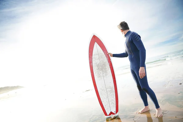 Surfista em pé na praia de areia — Fotografia de Stock