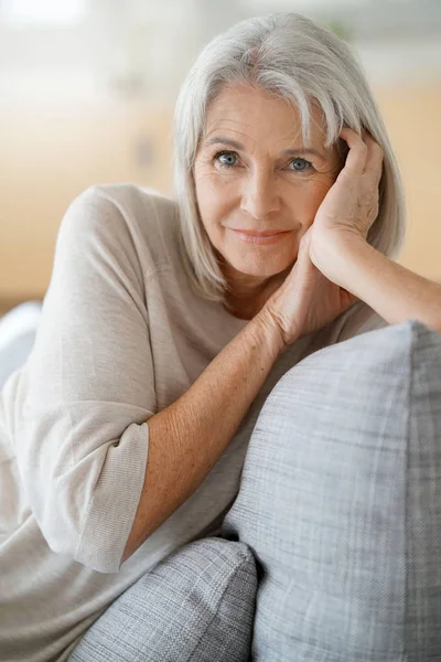 Пожилая женщина расслабляется на диване — стоковое фото